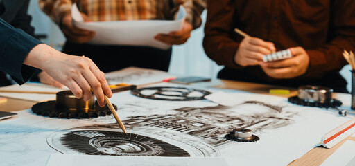Engineers engage in a dynamic discussion over intricate technical drawings in a collaborative workspace, illustrating creativity and teamwork in project development. SACTR