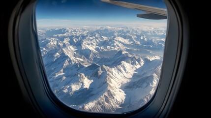 Aerial View of Snow-Capped Mountains Through Airplane Window.