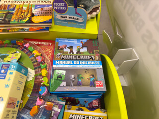 Fototapeta premium BELO HORIZONTE, MG, BRAZIL, DECEMBER 12, 2025 Popular children's books and playful toys fill a bright retail display, inviting young readers and gamers.