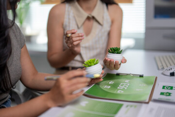 Businesswomen discussing esg compliance with potted plants