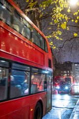 Obraz premium London streets at night glow with car headlights and reflections on wet roads, creating lively, atmospheric cityscape