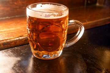 Classic London pub crawl with friends, enjoying cask ales and lively atmosphere of traditional British pubs, grasses of cask ales beer from barrels