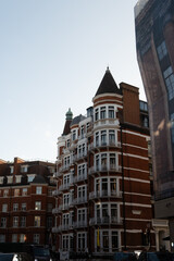 Fototapeta premium Stroll along Hans Crescent with elegant red brick townhouses and vibrant city life Knightsbrigde in London