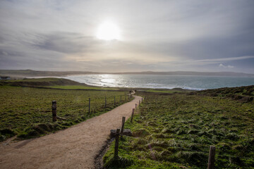 One of the coastal paths leading off into the setting sun at a beach in the UK.