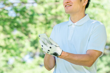Male golfer using smartphone at golf course (app, score, score management, course strategy, course map)