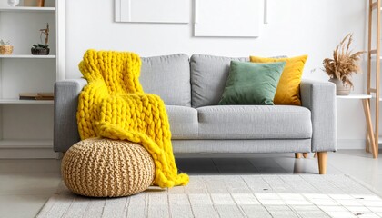 Cozy Modern Living Room Interior with Grey Sofa, Chunky Yellow Knitted Blanket, and Pouf