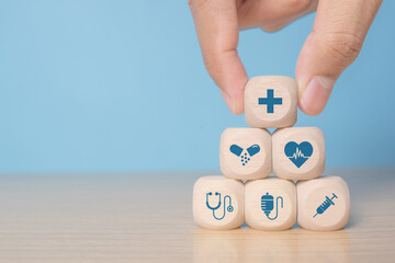 Businessman chooses a emoticon icons healthcare medical symbol on wooden blocK, Healthcare and medical Insurance concept
