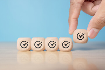 Hand holding wooden block with tick mark, good feedback rating and positive customer review, experience, satisfaction survey ,mental health assessment, checklist business concept