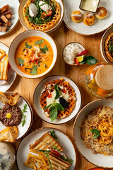 Colorful plates filled with delectable foods surround a rustic wooden table, highlighting an array of flavors and textures perfect for sharing with friends or family