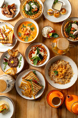 A vibrant selection of dishes fills the wooden table, showcasing diverse flavors and textures. Friends share laughter and stories while enjoying their meal on a bright afternoon