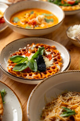 Colorful dishes filled with flavor are beautifully arranged on a wooden table. The atmosphere is lively as friends enjoy a delightful meal, sharing laughter and joy