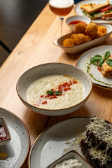 A tempting spread of delicious dishes showcases creamy risotto topped with fresh tomatoes, alongside crispy snacks and fresh herbs. Perfect for a cozy gathering