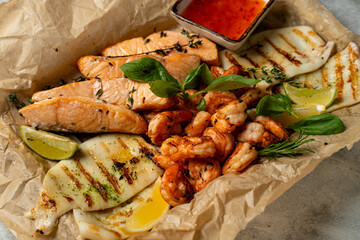 A vibrant seafood platter showcases perfectly grilled salmon, shrimp, and squid garnished with fresh herbs and lime, inviting everyone to enjoy a delightful meal filled with flavor