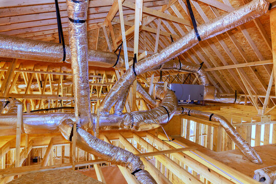 Construction site ductwork installation in new building under construction with wood framing