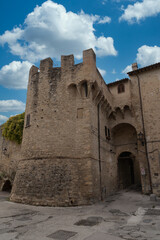 Porta Molini one of the city gates of Bevagna Italy protected by a round bastion with cloudy blue sky
