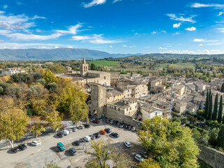Aerial view of Bevagna medieval town center with city walls, gates, towers, Gothic churches with blue sky