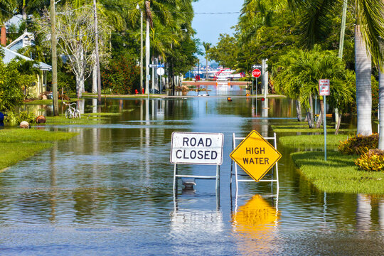 Road closed because of flooding danger with warning signs blocking driving of cars. Hurricane Milton aftermath in Punta Gorda, Florida
