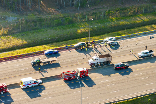 Severe car crash with first responders helping at accident site on American highway. Vehicle collision on high speed road in USA.