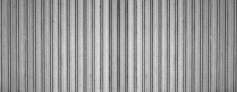 Steel corrugated panel with silver metal texture and iron sheet of zinc. Container roof and plate of white wall with tile pattern in aluminum. Vertical siding galvanized with ribbed surface.