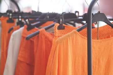 Hanging orange clothes in a retail shop display