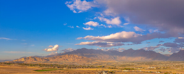 Obraz premium Homes and majestic mountain under sky with clouds