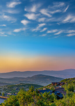 Layers of sunset hills with homes foreground