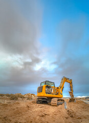 Obraz premium Excavator scooping and leaving tread marks on dirt