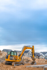 Excavator with Utah Valley homes in background