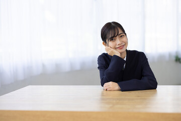 Young Businesswoman Smiling with Hands Under Chin at Desk