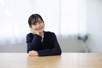 Young Businesswoman Smiling with Hands Under Chin at Desk