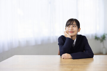Young Businesswoman Smiling with Hands Under Chin at Desk