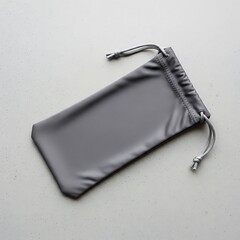Minimalist gray drawstring pouch laying on a textured surface flat lay