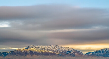Panorama of a majestic mountain covered with snow and illuminated by sunlight