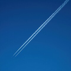 Two parallel contrails in blue sky