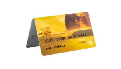 Credit card featuring a coastal sunset design, held upright by a gray rectangular stand