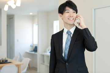 リビングで電話するビジネスマン