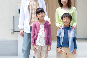 自宅の玄関先に立つ家族 © UTS