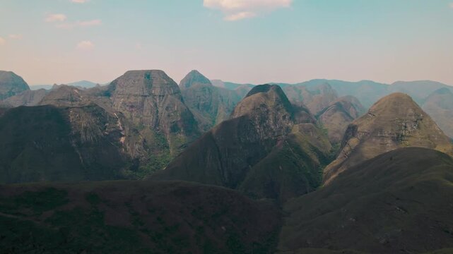 A breathtaking wide aerial or drone shot capturing the vast, rugged, and majestic landscape of the Codo de los Andes mountain range in Bolivia under a clear blue sky, emphasizing natural beauty