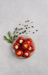 Red cherry peppers Sweet and spicy stuffed with cheese on ceramic plate. The milder "sister" of Peppadew.