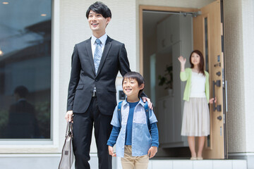 玄関先で見送る母親と家族 © UTS
