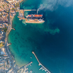 Kusadasi, Turkey. Straight down aerial view of bay with cruise liners emitting smoke at pier. Beaches and coastline from vertical perspective. Aerial view.