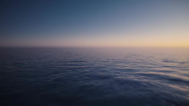 Calm ocean waters meet a gradient sky at dawn or dusk