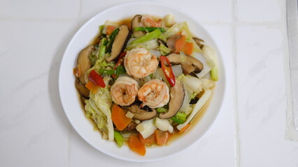 Stir-fried mixed vegetable with shrimps and shiitake mushroom isolated on white background.
