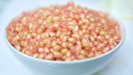 pomegranate seeds in a bowl, shallow depth of field