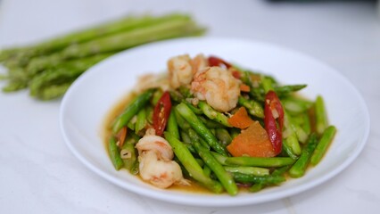 Stir-fried asparagus with shrimp and chili on white plate