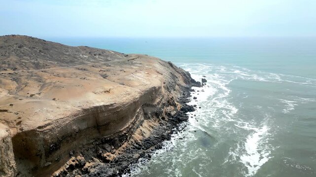 Aerial view of the coast of Eten, Lambayeque in northern Peru, with the lighthouse overlooking the Pacific Ocean and the arid coastal landscape in summer