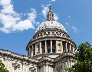 Iconic dome of St. Paul's Cathedral in London under a blue sky.