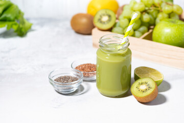 healthy superfood - green smoothie made from fruits and herbs on white table, top view