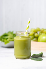 healthy superfood - green smoothie made from fruits and herbs, vertical closeup
