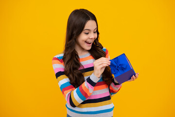 Child with gift present box on isolated background. Presents for birthday, Valentines day, New Year or Christmas. Happy teenager, positive and smiling emotions of teen girl.